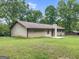 View of the backyard showing the well-maintained lawn, trees, and the rear exterior of the home at 110 Thompson Blvd, Stockbridge, GA 30281