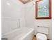Bright bathroom with a shower-tub combination and natural light from the window at 110 Thompson Blvd, Stockbridge, GA 30281