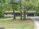 A single-Gathering home with an attached garage is surrounded by lush green trees and a well-manicured lawn at 110 Thompson Blvd, Stockbridge, GA 30281
