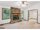 Living room featuring a stone fireplace, neutral carpet, and natural light from large windows at 110 Thompson Blvd, Stockbridge, GA 30281