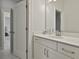 Bathroom vanity with white countertop and cabinetry, a large mirror, and white walls at 307 Owenberg Trce, Peachtree City, GA 30269