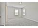 Spacious bedroom features neutral gray walls, carpet, base trim and two windows with blinds at 307 Owenberg Trce, Peachtree City, GA 30269