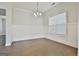 Light-filled dining room with hardwood floors, paneled walls, and elegant light fixture at 307 Owenberg Trce, Peachtree City, GA 30269