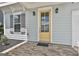 Close up of a yellow front door with glass panels, flanked by black sconces and a brick porch at 307 Owenberg Trce, Peachtree City, GA 30269