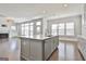 Open kitchen with island, stainless steel sink, and plenty of light from the windows at 307 Owenberg Trce, Peachtree City, GA 30269