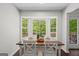 Bright breakfast nook features a wood table, white chairs, and a window overlooking a wooded backyard at 2698 Pleasant Grove Church Rd, Villa Rica, GA 30180
