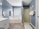 A full bathroom features a garden tub, a glass shower, tile floors, and a single sink vanity at 1112 Haver Ct, Mcdonough, GA 30252