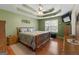 A bedroom features a queen bed, tray ceilings, wood floors, and a window with blinds at 1112 Haver Ct, Mcdonough, GA 30252