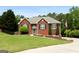 Charming red brick home with manicured lawn, mature trees, and inviting curb appeal at 1112 Haver Ct, Mcdonough, GA 30252