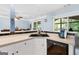 A kitchen and breakfast bar features a stainless steel dishwasher, a view outside, and tan countertops at 1112 Haver Ct, Mcdonough, GA 30252