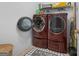 Bright laundry room showcases large, modern, front-loading washer and dryer on a tiled floor at 1112 Haver Ct, Mcdonough, GA 30252