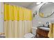 Well-lit bathroom features vintage-style vanity and a shower with a yellow curtain at 118 Duvall Dr, Stockbridge, GA 30281