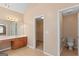 Bright bathroom vanity including an illuminated mirror, a sink, and a nearby walk-in closet at 21 Highbush Ct, Sharpsburg, GA 30277