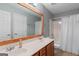 This bathroom features dual sinks, a toilet, and a bathtub with shower behind a decorative framed mirror at 21 Highbush Ct, Sharpsburg, GA 30277