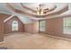 Spacious bedroom featuring neutral carpet, tray ceiling, and multiple windows providing plenty of natural light at 21 Highbush Ct, Sharpsburg, GA 30277