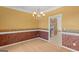 Formal dining room featuring chair rail detail, chandelier, and view to the kitchen at 21 Highbush Ct, Sharpsburg, GA 30277