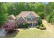 Beautiful two-story home with a stone and vinyl exterior, lush lawn, and mature trees at 21 Highbush Ct, Sharpsburg, GA 30277