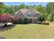 Two-story traditional home featuring stone accents, a well-manicured lawn and mature trees at 21 Highbush Ct, Sharpsburg, GA 30277