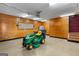 Garage with wooden panels and storage, featuring a green John Deere lawnmower at 21 Highbush Ct, Sharpsburg, GA 30277