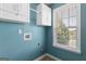 Bright laundry room with upper cabinets and a window providing plenty of natural light at 21 Highbush Ct, Sharpsburg, GA 30277