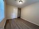 A bedroom with neutral walls, modern floors, a window, and a white door at 7336 Howard Cir, Jonesboro, GA 30236
