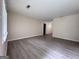 Bright, freshly painted living room with modern gray wood flooring, baseboards, and ample natural light from the window at 7336 Howard Cir, Jonesboro, GA 30236
