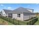 Beautiful backyard featuring a screened porch, green lawn, and black metal fencing at 737 Myrica Ave, Locust Grove, GA 30248