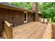 Wide angle view of a wooden back deck with chairs, brick house, chimney and natural surroundings at 215 Ridge Rd, Tyrone, GA 30290
