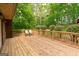 Wide angle view of a wooden back deck with chairs and surrounding lush green landscaping at 215 Ridge Rd, Tyrone, GA 30290