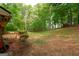 Wide angle view of a lush back yard with a home, deck, green bushes and surrounding landscaping at 215 Ridge Rd, Tyrone, GA 30290