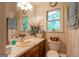 Cozy bathroom featuring a single vanity, wood cabinets, a decorative clock, and a window at 215 Ridge Rd, Tyrone, GA 30290