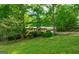 Well-kept home featuring brick facade, covered porch, attached garage, and surrounded by mature trees at 215 Ridge Rd, Tyrone, GA 30290