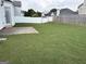 A large backyard with both wooden and white fences and a concrete patio area at 1130 Ivey Ln, Mcdonough, GA 30253