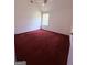 An empty bedroom has red carpets, a window, and ceiling fan at 1130 Ivey Ln, Mcdonough, GA 30253