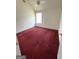 A roomy bedroom has red carpets, a window, and ceiling fan at 1130 Ivey Ln, Mcdonough, GA 30253