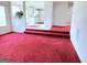 Open-concept living space with red carpet, steps to the kitchen, and white trim at 1130 Ivey Ln, Mcdonough, GA 30253
