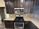 Close-up of the kitchen with stainless steel gas range and oven, microwave, and granite countertops at 960 Spanish Moss Trl, Loganville, GA 30052