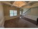 Spacious living room featuring a coffered ceiling, elegant chandelier, and stylish wainscoting, seamlessly blending carpet and hardwood flooring at 960 Spanish Moss Trl, Loganville, GA 30052