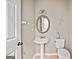 Cozy bathroom featuring a pedestal sink, toilet, and a round mirror, offering a simple, functional space at 542 Creek Stone Ln, Stone Mountain, GA 30087