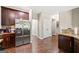 Open kitchen area featuring stainless steel refrigerator, hardwood floors, and dark wood cabinetry at 542 Creek Stone Ln, Stone Mountain, GA 30087