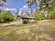 The back of this painted brick home features a wooden deck and a spacious yard surrounded by mature trees at 15 Laurie Ln, Covington, GA 30016