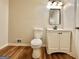 Bathroom with modern vanity, mirror, and wood look flooring with a toilet at 15 Laurie Ln, Covington, GA 30016