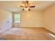 Spacious bedroom features neutral carpeting, a large window, and a ceiling fan for comfort at 15 Laurie Ln, Covington, GA 30016