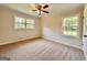 Bright bedroom featuring two large windows and neutral carpet flooring with a ceiling fan at 15 Laurie Ln, Covington, GA 30016