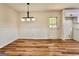 Bright dining room featuring wood flooring, beadboard accent, and modern lighting fixture near the kitchen at 15 Laurie Ln, Covington, GA 30016