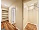 Bright hallway with beautiful wood-look flooring leading to a closet with built-in shelving and wire racking at 15 Laurie Ln, Covington, GA 30016