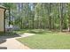 Sprawling backyard with lush green grass and mature trees beyond the patio at 110 Greenridge Ct, Fayetteville, GA 30215