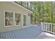 Gray wooden deck with white railings offers a view of the wooded backyard at 110 Greenridge Ct, Fayetteville, GA 30215