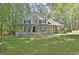 Charming two-story home boasts a full front porch and mature landscaping at 110 Greenridge Ct, Fayetteville, GA 30215