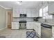 Bright kitchen features white cabinets, stainless steel appliances, granite countertops, and tile backsplash at 110 Greenridge Ct, Fayetteville, GA 30215